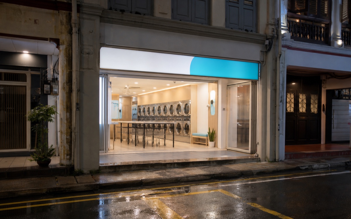 AI-generated concept of a clean laundromat shopfront in a Singapore shophouse row at night